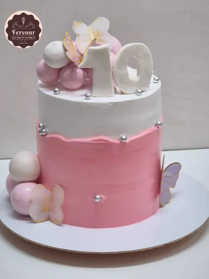 A pink and white ombre cake for a 10th birthday. This mocha chocolate cake is decorated with spheres and butterflies for a simple yet beautiful design.