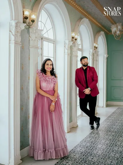 A stylishly posed shot in a European-style corridor, using the leading lines of the architecture to draw attention to the couple.