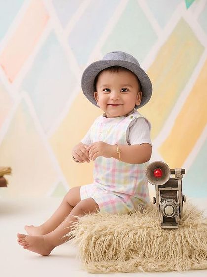A little world traveler getting ready for his next adventure. This setup with vintage luggage and a globe sparks the imagination.