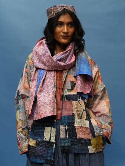 A direct portrait that highlights the incredible detail of a patchwork kantha jacket. Each patch tells a story, making this a truly unique piece of wearable art.