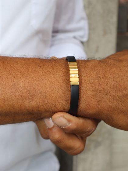 A modern and sophisticated choice for dad. This bracelet features a black band with a central gold accent piece, offering a look of understated luxury.