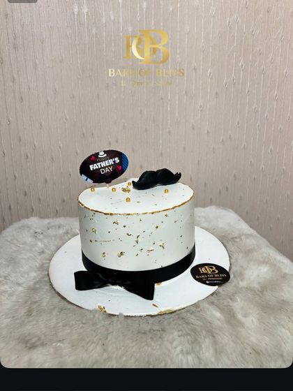 A simple and elegant Father's Day cake with a mustache detail and a "Father's Day" topper, perfect for celebrating your dad.