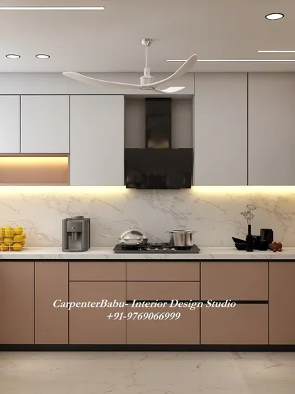 A kitchen with a beautiful dusty rose color for the lower cabinets, paired with white upper cabinets. The built-in oven and chimney create a sleek, integrated look.