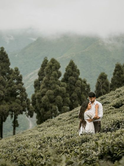 An intimate embrace in a foggy tea garden. The mist enveloping the couple creates a dreamy and ethereal atmosphere, focusing entirely on their connection.