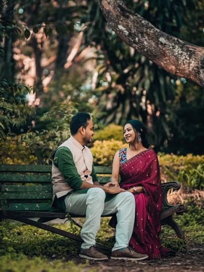 A quiet conversation on a rustic park bench, surrounded by the deep greens of nature. This shot highlights our ability to capture the simple, beautiful moments of your relationship.