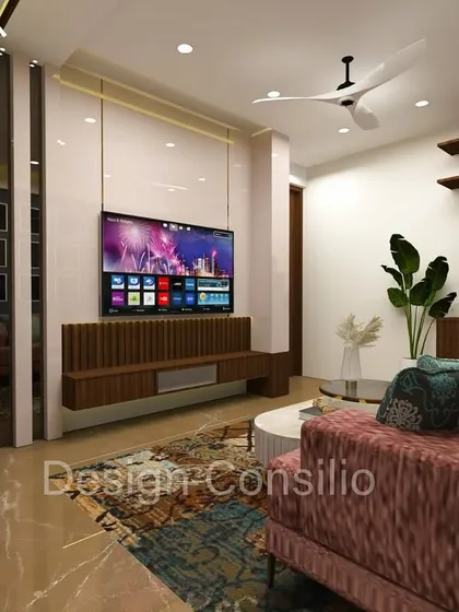 A cozy living room setup with a pink sofa and a colorful rug. The floating wooden TV console keeps the floor clear, making the room feel more spacious.