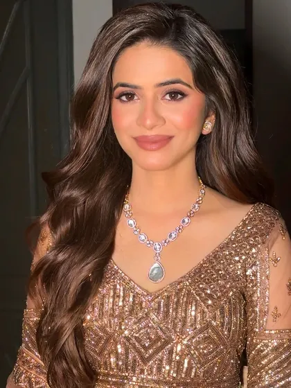 A smiling portrait that shows the versatility of a nude makeup and soft curls look. It's classic, beautiful, and suits any occasion.