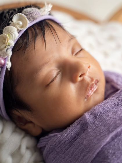 So tiny and perfect. This macro shot captures the delicate features of a newborn, from her soft lips to her tiny nose, in peaceful sleep.