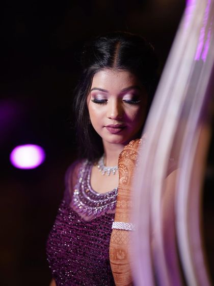 A close-up of the glamorous sangeet makeup. The shimmery lilac eyeshadow and the bold lip create a look that is perfect for a night of celebration.