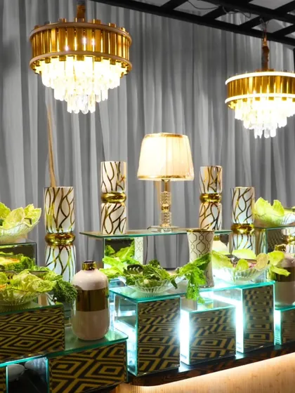 A stunning salad bar setup with modern, illuminated risers and crystal chandeliers. We work closely with you to create a personalized experience tailored to your unique vision.