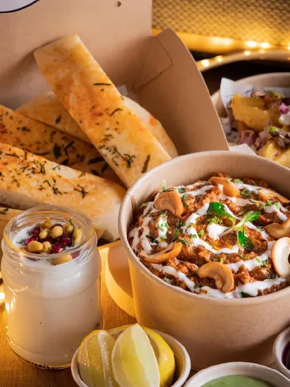 A closer look at my North Indian platter, featuring a rich, creamy curry served with garlic bread and a yogurt-based side.