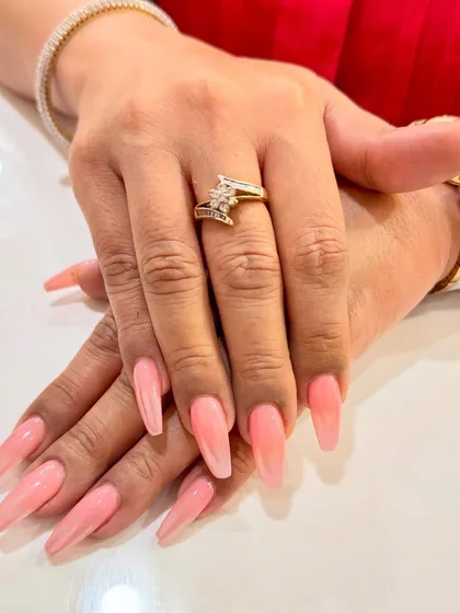 These long, coffin-shaped nails showcase a beautiful pink ombré effect. The color melts from a soft, milky base into a gentle pink, creating a subtle and feminine look that is both modern and elegant.