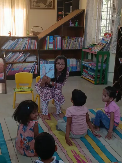 The storyteller shows a picture from the book, her expression full of warmth and encouragement.