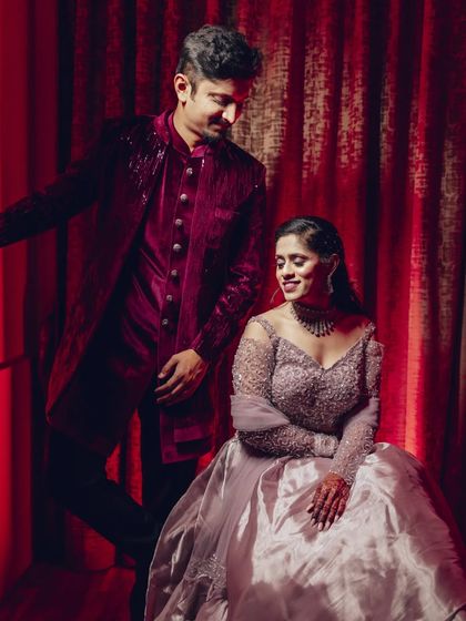 Using rich, warm lighting to create a dramatic and elegant portrait. The deep red background complements the couple's outfits and adds a touch of glamour to the sangeet photos.