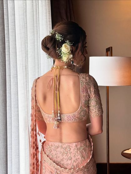 A view from the back of Maansi's floral updo. This classic hairstyle is perfect for securing a dupatta while still looking soft and beautiful.