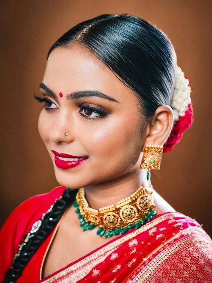 This profile view highlights the clean, sleek hairstyle and the precision of the eye makeup, essential for this traditional look.