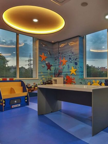 Another view of the ocean-themed room, featuring a car-shaped bookshelf and large windows. The design ensures ample natural light and provides different zones for reading, playing, and learning.