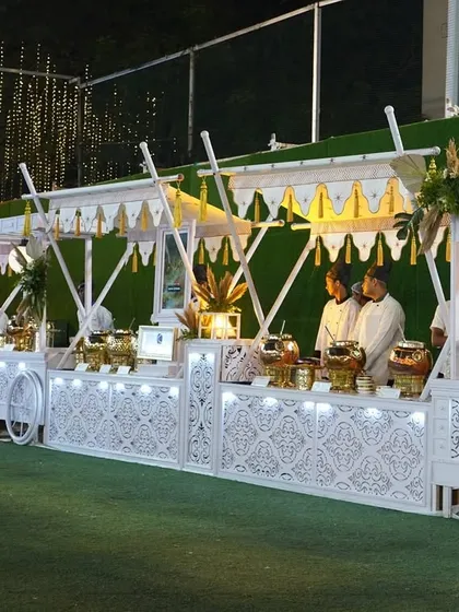 An elegant, all-white buffet setup designed to look like royal food carts. The intricate latticework and clean lines create a sophisticated and regal atmosphere for any upscale wedding or social gathering.