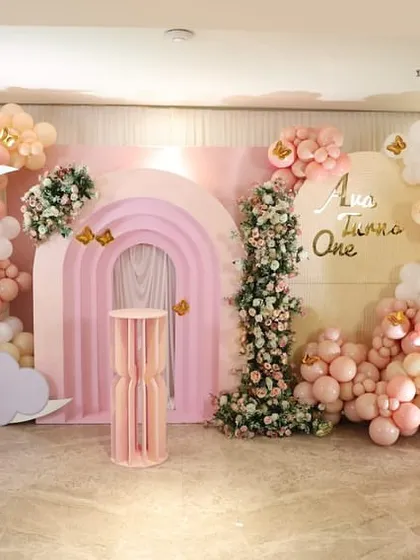 The full party setup, including the main backdrop and a welcome sign, demonstrates a cohesive and beautifully executed butterfly and floral theme for a first birthday.