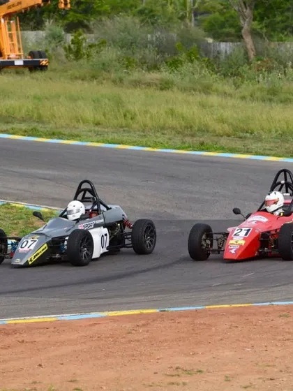 An intense on-track battle between two Formula LGB cars, highlighting the competitive nature of the championship.