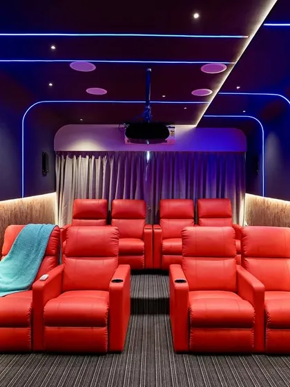 This is our vision for the ultimate home theater experience. We combined bold red leather recliners with dynamic blue profile lighting and professional-grade acoustics to create a vibrant, immersive space for watching movies at home.
