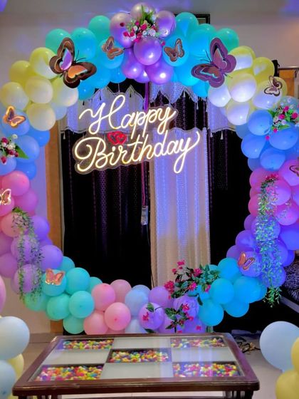 A whimsical butterfly-themed birthday ring in rainbow pastel colors, perfect for a dreamy celebration.