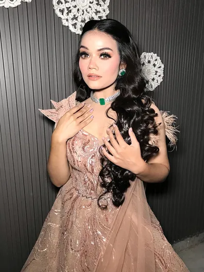 This angle shows the feather details on her gown, which are complemented by her sparkling jewelry.