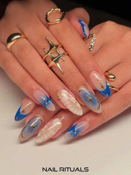When your nails whisper secrets of the stars. This dreamy blue and white set features cosmic-inspired art with delicate star details and gold accents.