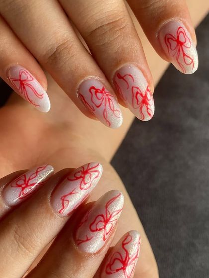 A full view of the coquette-style red bow nail art. It's simple, chic, and so in style right now.