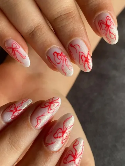 A full view of the coquette-style red bow nail art. It's simple, chic, and so in style right now.