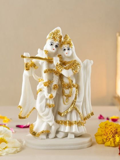 An exquisite sculpture of Radha and Krishna, capturing a moment of divine harmony. Crafted in white and gold, this piece is a beautiful symbol of love and devotion for your home.