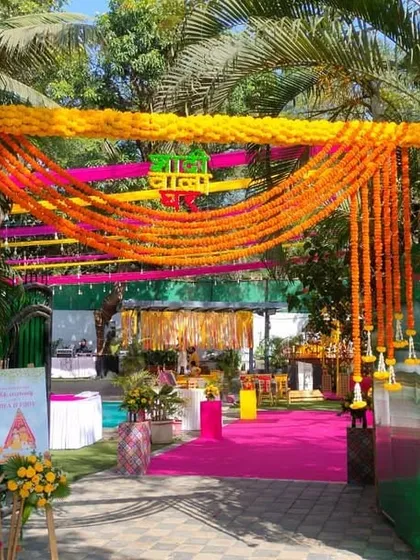 A festive entrance to a Haldi ceremony, decorated with marigold garlands and colorful drapes. The "Haldi" sign in Hindi adds an authentic, traditional touch.