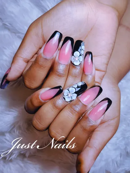 The perfect blend of classic and creative. This design combines a sharp, v-shaped black French tip with accent nails featuring stunning, hand-sculpted 3D white flowers.