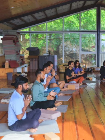 A group of students in a seated meditation, finding their center before we begin our asana practice.