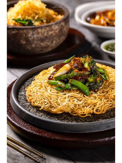 Another view of the crispy noodles, highlighting the glossy sauce and fresh vegetables.