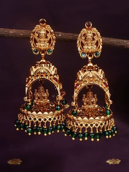 For a classic look, I offer these matte gold finish temple jhumkis with emerald green bead drops. The Goddess Lakshmi motif adds a divine touch.