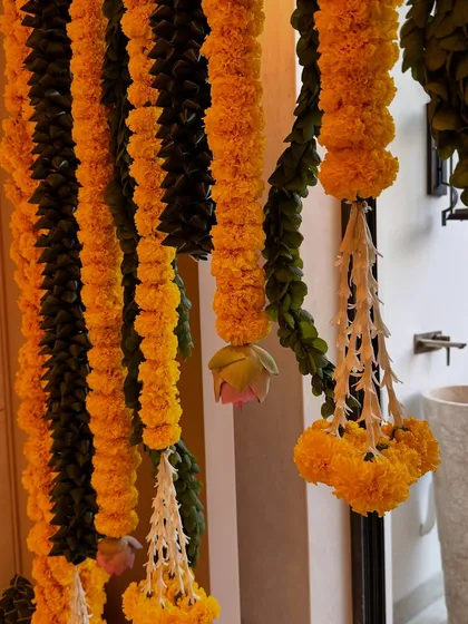 There's something so special about traditional housewarming decor. Here, I've used classic genda phool (marigold) garlands with delicate jasmine tassels to create a warm and auspicious welcome for a new beginning.