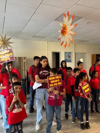 Our students line up before their performance, holding signs for the songs they prepared. This behind the scenes shot shows the anticipation and teamwork involved in our 'Togetherness Initiative' events.