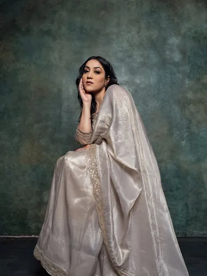A full-length portrait showcasing the entire look. The makeup is balanced and elegant, perfect for the timeless appeal of the saree.