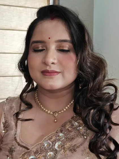 This shot highlights the beautiful golden shimmer on the eyelids, which is perfectly complemented by the soft, romantic curls in her hair.