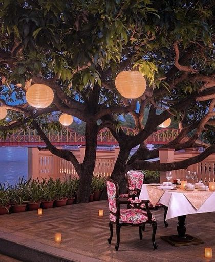 We believe design extends beyond the four walls. Our custom floral upholstered chair sits beautifully in this magical alfresco dining setup at IHCL Pilibhit House, blending seamlessly with the natural and ambient light.