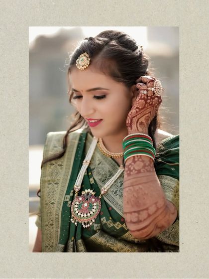 A classic bridal portrait focusing on the intricate details of her jewelry and the rich green of her saree. A timeless shot for any wedding album.