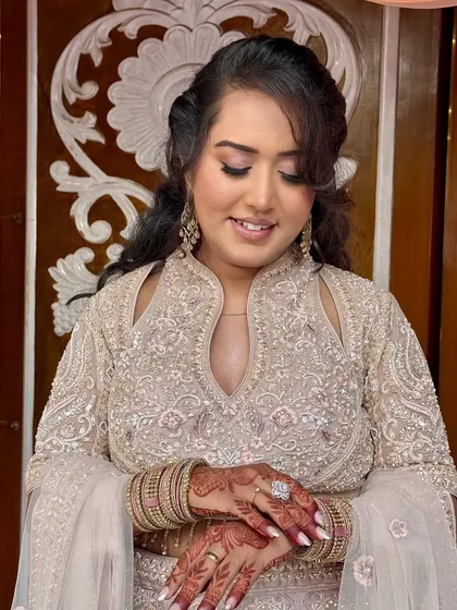 A close-up of the bride admiring her henna. The makeup is soft and romantic.