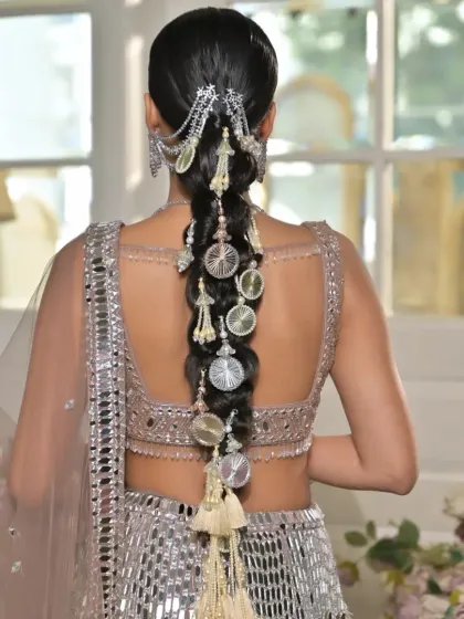 This is a modern take on a traditional bridal braid, crafted for a jewellery brand campaign. I used intricate silver hair accessories and charms to match the mirror-work lehenga, resulting in a contemporary and cohesive look.