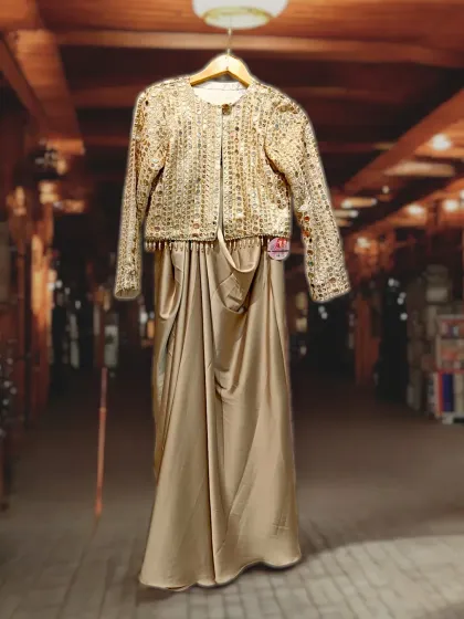 This is an exquisitely beautiful gold drape skirt paired with a stunningly embroidered jacket. The combination radiates a unique elegance and sophistication, perfect for a high-fashion statement.