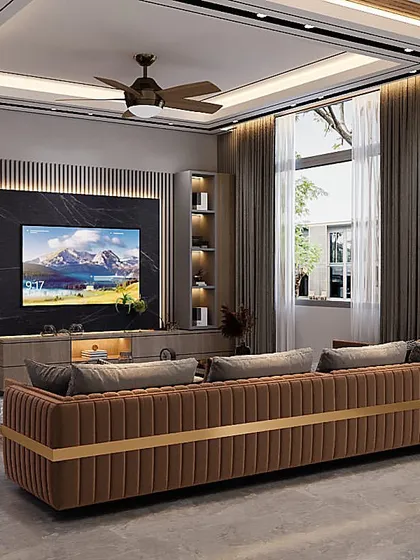 This living room is designed for comfort and style, with a long, channel-tufted sofa providing ample seating. The design incorporates a mix of wood tones and a dark marble TV panel for a warm, contemporary feel.