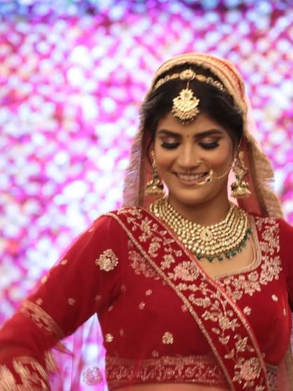 A candid moment of bridal joy. The multi-layered Kundan necklace with green beads is a popular rental choice for its royal and traditional appeal.