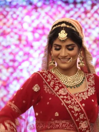 A candid moment of bridal joy. The multi-layered Kundan necklace with green beads is a popular rental choice for its royal and traditional appeal.