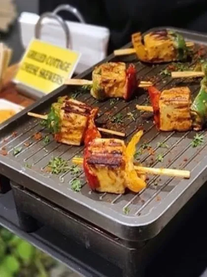 Live cooking stations add excitement to any event. Here, I am grilling paneer tikka skewers with colorful bell peppers, served hot and fresh to guests at a Diwali party.