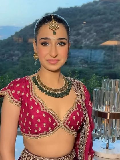 The groom's sister looking regal with a traditional South Indian temple jewelry braid, a perfect hairstyle for a grand wedding celebration.